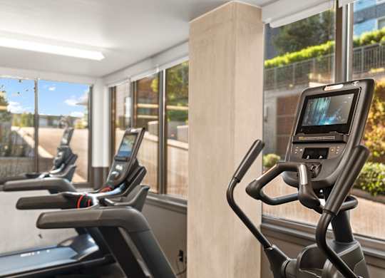 a gym with cardio machines and windows in a building at Baldwyn, Seattle