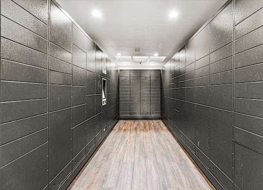 A long hallway with wood floors and grey walls.