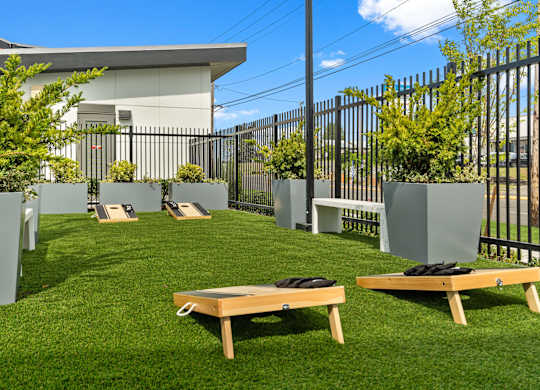 a grassy area with benches and plants and a fence at Gage On Sixth, Tacoma, WA, 98465