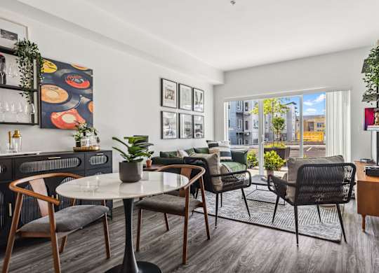a living room with a table and chairs and a large window at Gage On Sixth, Tacoma, WA