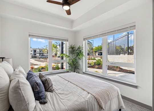 a bedroom with large windows and a bed with pillows at Gage On Sixth, Tacoma, WA, 98465