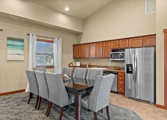 A kitchen with a dining table and chairs.