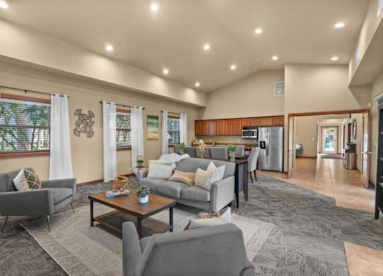 A spacious living room with a grey sofa set and a coffee table.