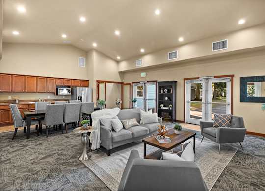 A well-lit living room with a grey sofa set and a wooden coffee table.
