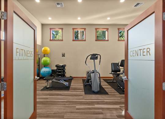 A fitness center with exercise equipment and a mirror.