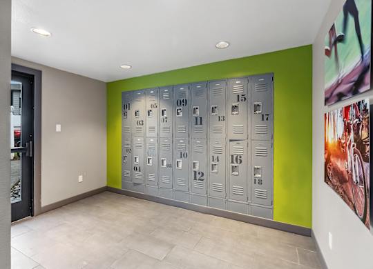 A row of metal lockers numbered from 09 to 18 are lined up against a green wall.