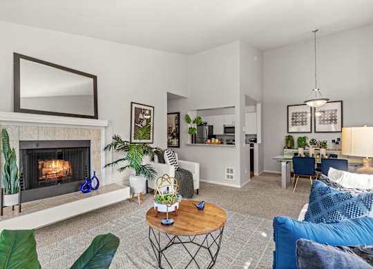 A living room with a fireplace and a blue couch.