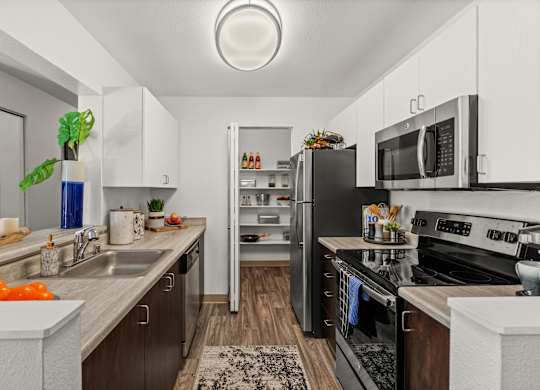 A modern kitchen with a refrigerator, stove, and microwave.