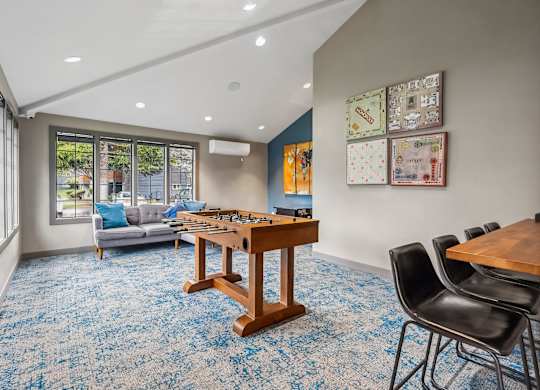 A room with a blue carpet and a wooden table.
