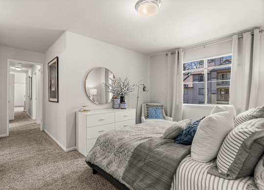 A bedroom with a bed, dresser, and mirror.