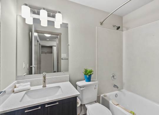 A white bathroom with a sink, toilet, and bathtub.