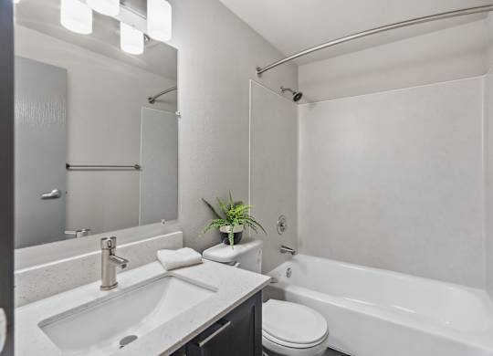 A white bathroom with a sink, toilet, and bathtub.