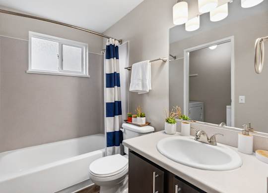 A bathroom with a white bathtub, toilet, and sink.