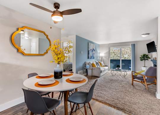 A dining room with a round table set for four.