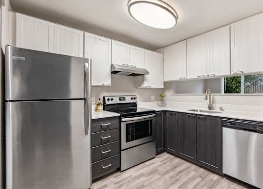 A modern kitchen with a stainless steel refrigerator and a stove top oven.
