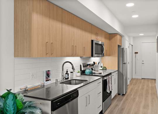 a kitchen with white cabinets and black counter tops and a sink