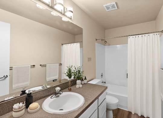 A bathroom with a sink, mirror, and shower.