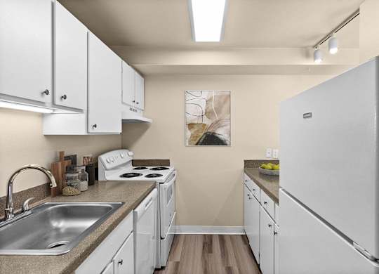A kitchen with white cabinets and a white fridge.