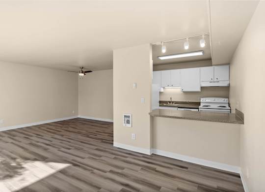 A room with a ceiling fan and a kitchenette area.