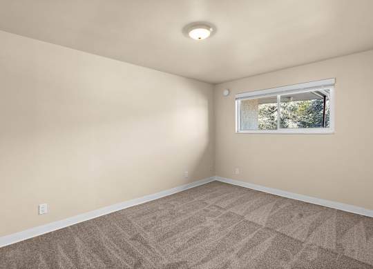 A room with a window and carpeted floor.