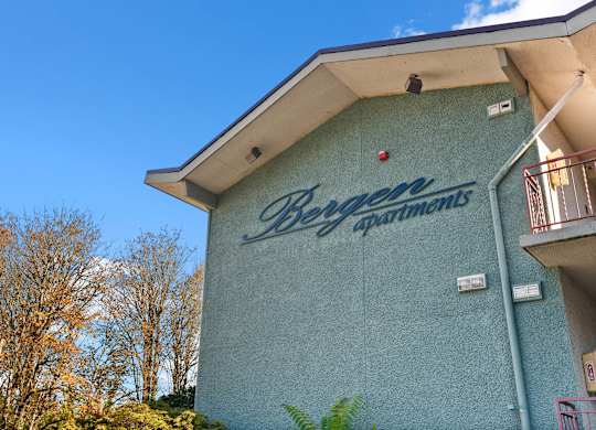 A blue building with the words Bergen Apartments on it.