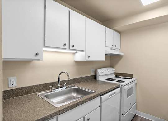 A kitchen with white cabinets and a stove top oven.