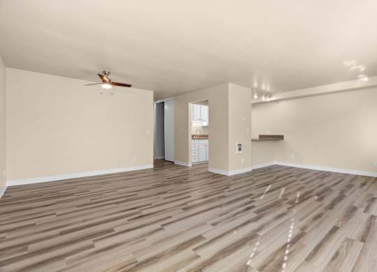 A room with wooden flooring and a ceiling fan.
