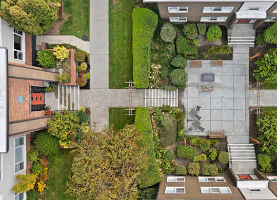 A courtyard surrounded by buildings with a bench and a table in the middle.