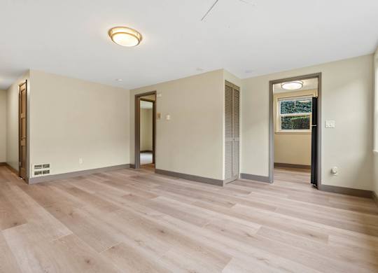 A room with wooden flooring and a ceiling light.