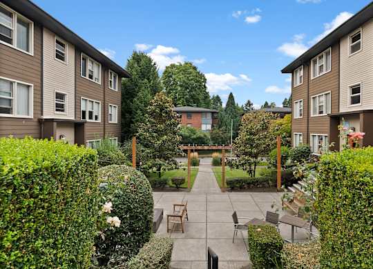 A sunny day at a residential area with apartment buildings and a garden.