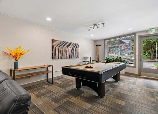 A room with a pool table and a bench.