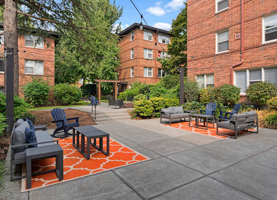 A patio with a table and chairs surrounded by a brick building.