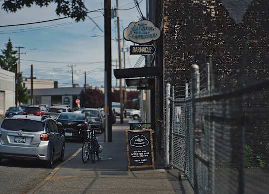 A street view of a parking lot with cars and a sign that says