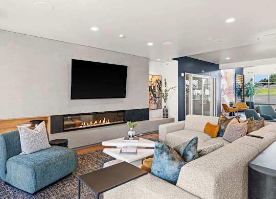 A modern living room with a fireplace and a flat screen TV mounted on the wall.