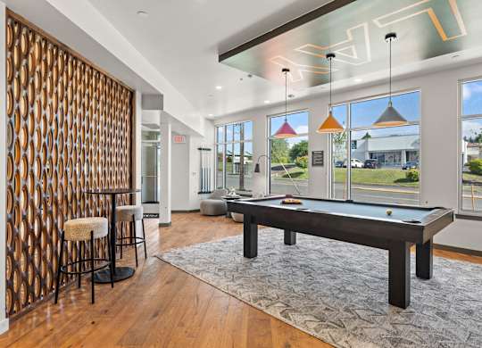 A room with a pool table and a bar.