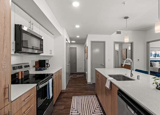 A modern kitchen with wooden cabinets and black appliances.
