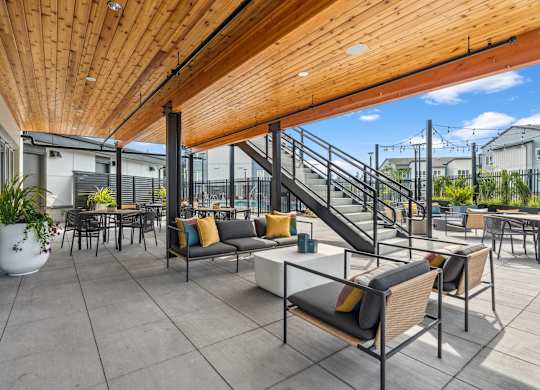 A patio with a wooden ceiling and grey floor tiles.
