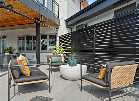A patio with two chairs and a table with a bowl on it.