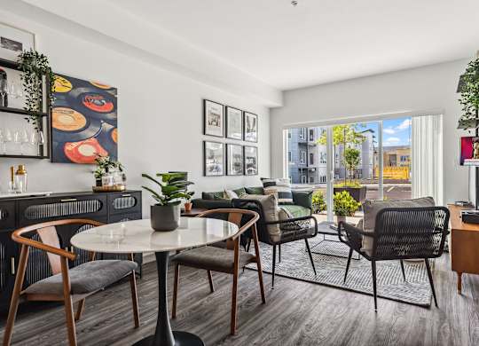A modern living room with a dining table and chairs.