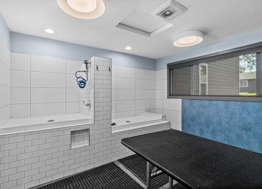 A modern bathroom with a black countertop and white tiles.