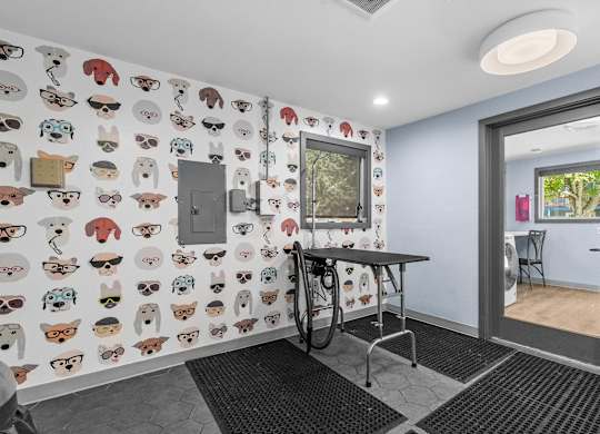 A room with a table and chairs and a wallpaper with cartoon animals.
