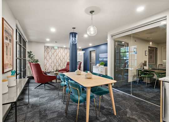 A dining room with a table surrounded by chairs.