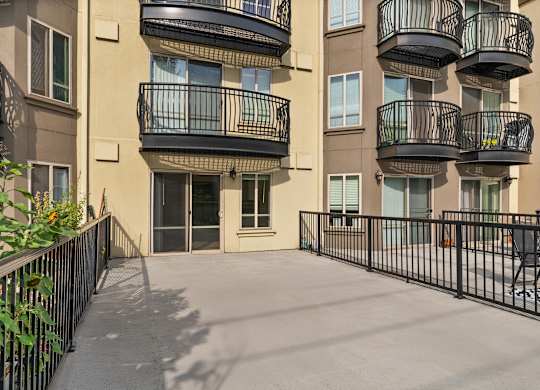 A balcony of a building with a black railing.