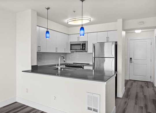 A modern kitchen with a stainless steel refrigerator and a center island.