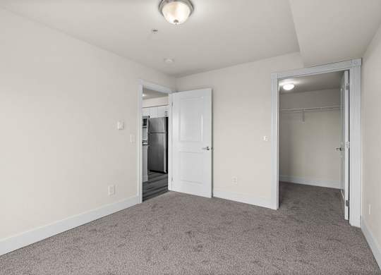 A room with a carpeted floor and a white door.
