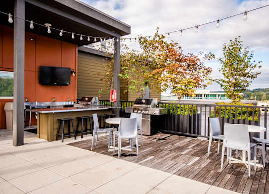 A patio with a table and chairs and a TV on the wall. at The Platform, Kent, Washington