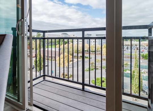 A balcony with a glass door and a black railing. at The Platform, Kent, Washington