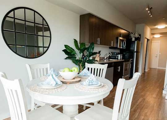 A white dining table with four chairs and a bowl of fruit on it. at The Platform, Washington, 98032
