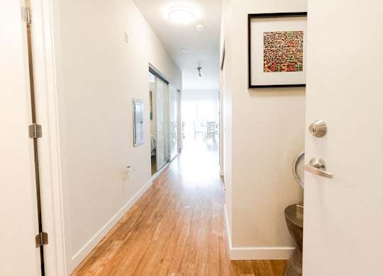 A hallway with a wooden floor and white walls. at The Platform, Washington, 98032