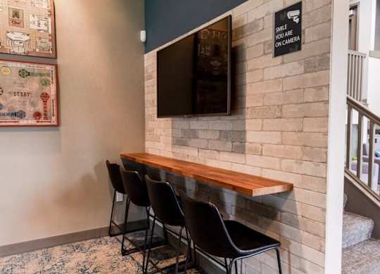 A room with a bench and chairs and a wall with a sign on it. at Vibe, Kent, Washington